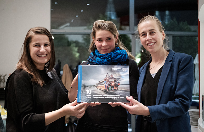 Ana Druga, créatrice, Helena Jansen, représentante de la commune lauréate et Marie Mévellec, chef de projet des partenariats pour le climat, présentent le livre de photos.